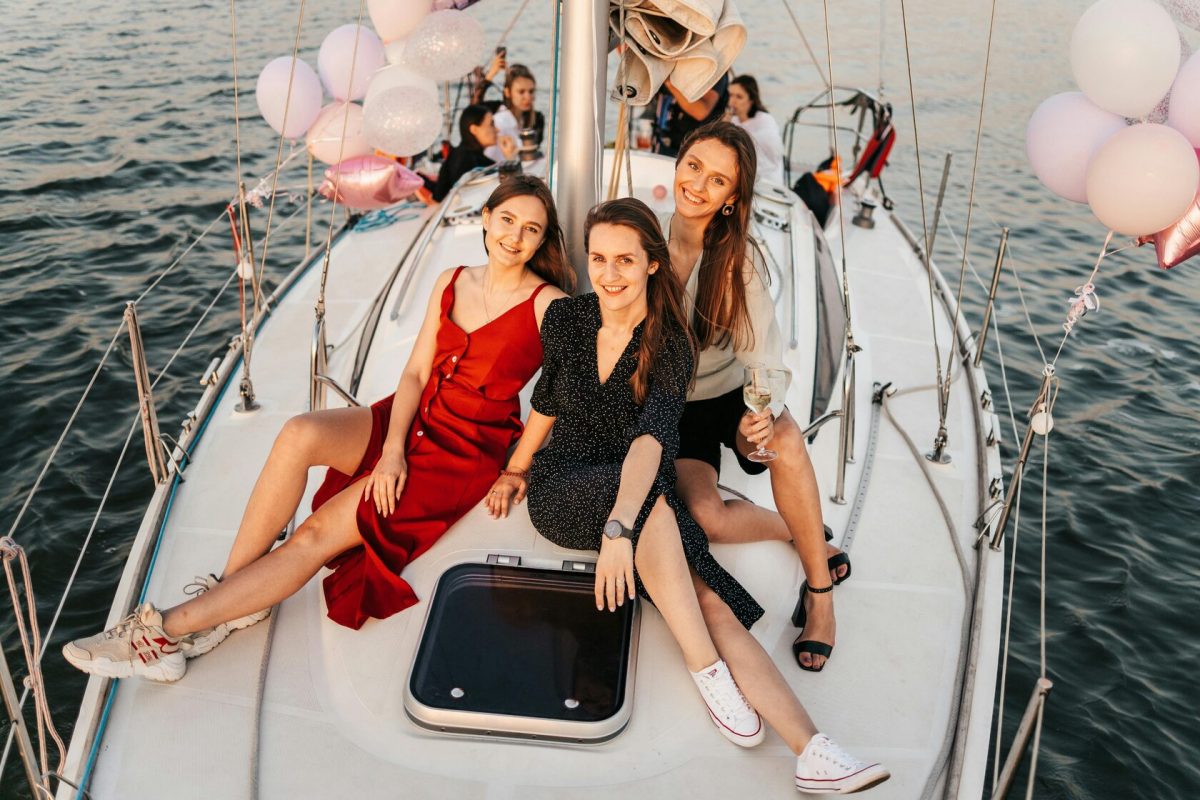 Group taking a selfie on a luxury yacht rental with the Dubai Marina skyline.